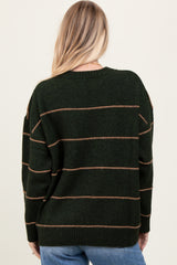 woman wearing a dark green oversized sweater with brown stripes, showing the back view