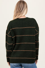 woman wearing a dark green oversized sweater with brown stripes, showing the back view