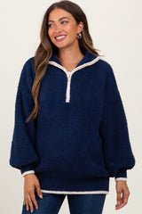 woman wearing a navy blue maternity pullover with a half zip and cream trim, smiling and styled for comfort
