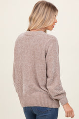 woman wearing a beige long sleeve knit sweater with a textured finish and ribbed hem, shown from the back