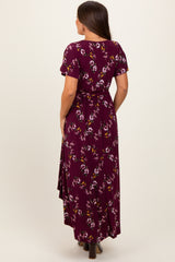 woman wearing a burgundy floral maxi maternity dress with short sleeves and a belted waist, showing a baby bump