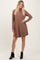 woman wearing a brown long sleeve ribbed mini dress and black ankle boots