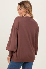 woman wearing a brown oversized sweater with balloon sleeves, viewed from the back