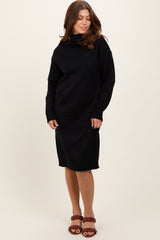 woman wearing a black oversized sweater dress with a high neckline and long sleeves