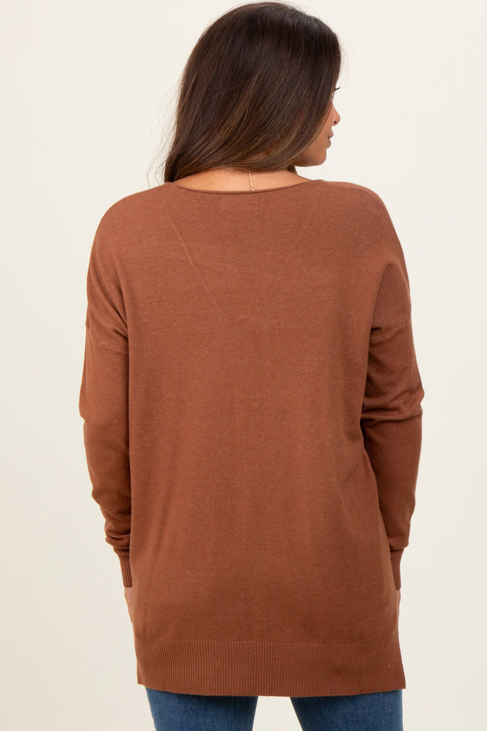 woman wearing a brown maternity sweater with a relaxed fit, seen from the back