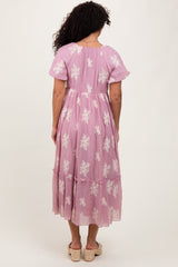 woman wearing a pink floral embroidered maxi dress with ruffled sleeves and tiered skirt from the back