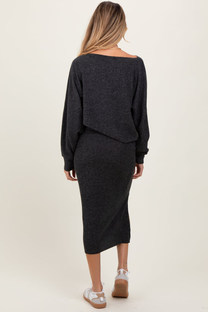woman wearing a dark gray maternity sweater dress with an off-the-shoulder design and long sleeves