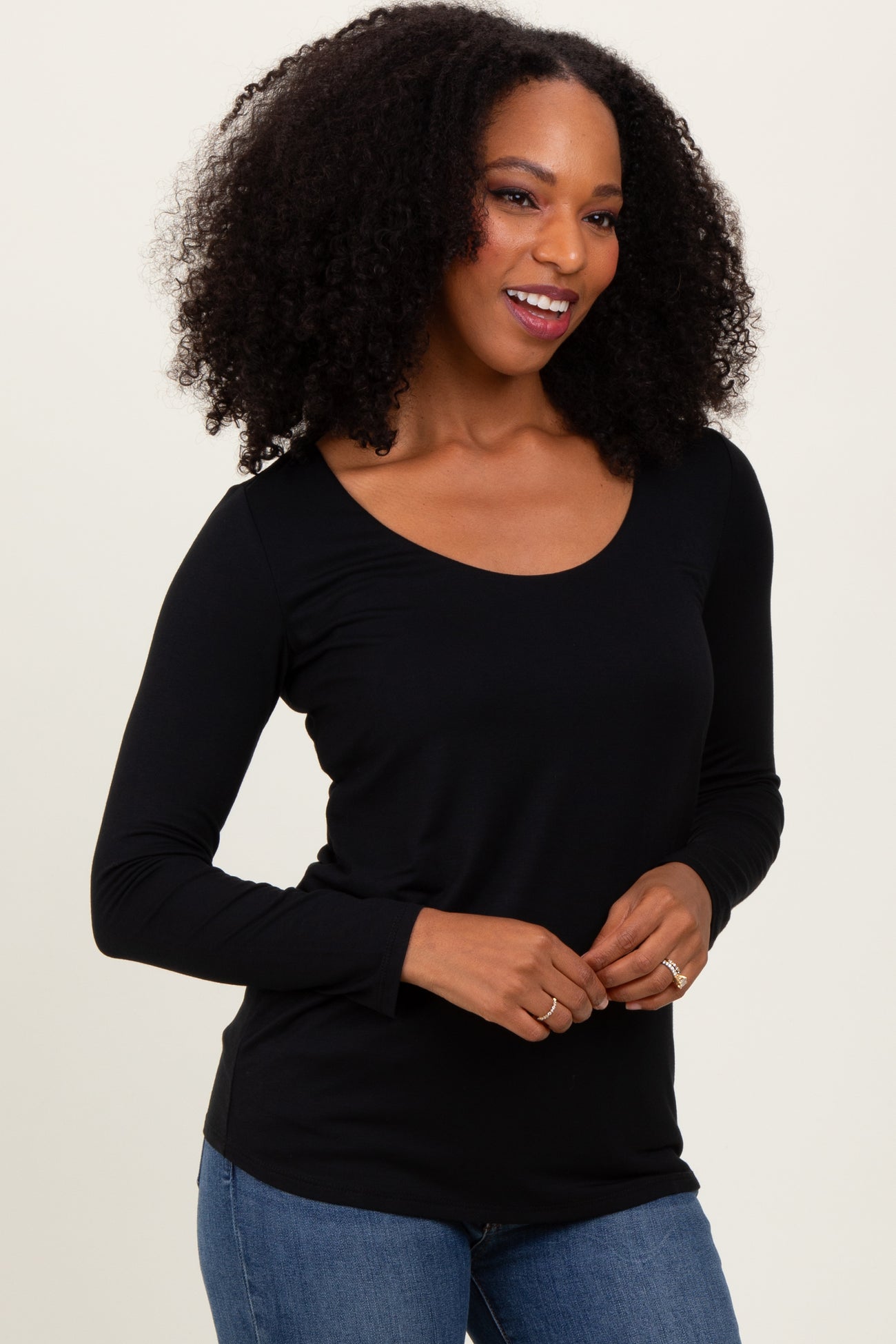 woman wearing a black long sleeve scoop neck top paired with blue jeans