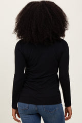 woman wearing a black long sleeve top and blue jeans, viewed from the back