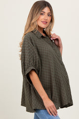 woman wearing a green checkered maternity shirt with a relaxed fit and rolled sleeves, showcasing her baby bump