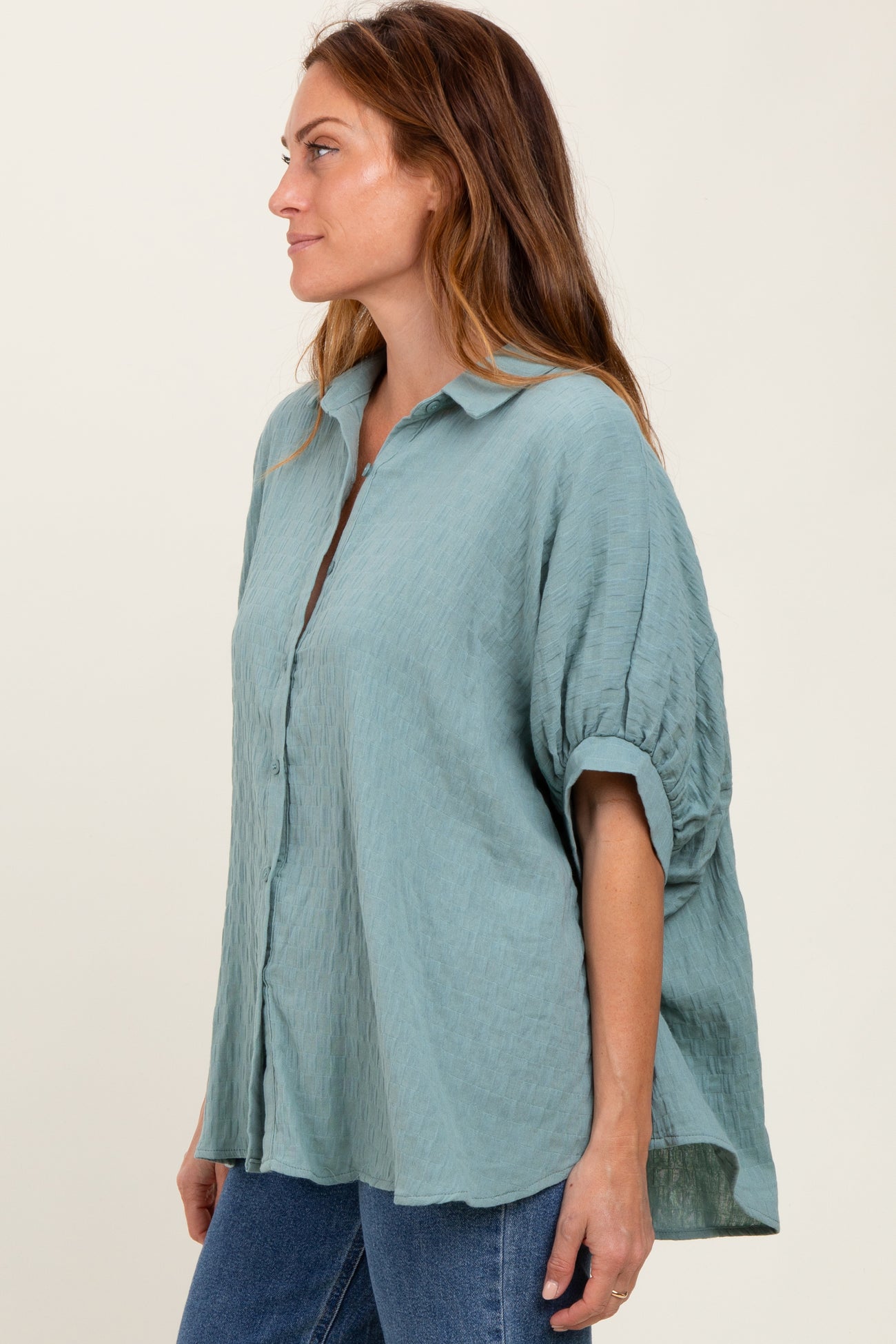 woman wearing a loose-fitting light blue button-up shirt with puffed sleeves and a relaxed silhouette