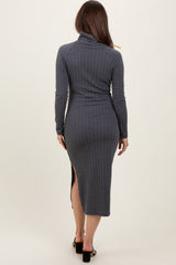 woman wearing a grey long sleeve maternity dress with a side slit and a fitted silhouette