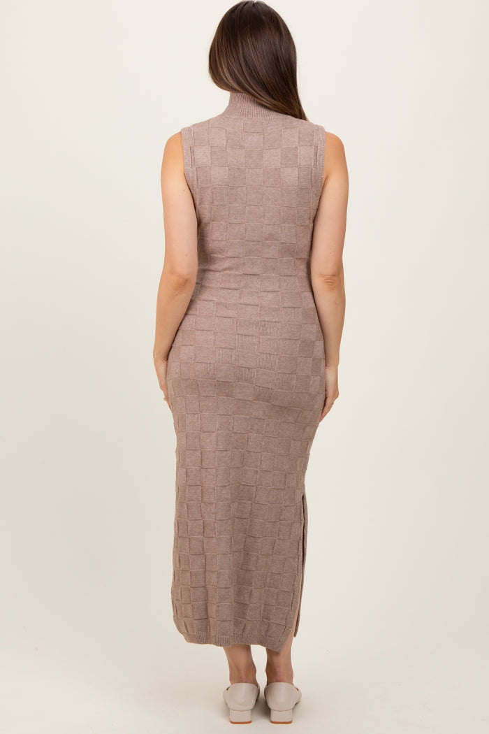 woman wearing a taupe sleeveless knitted maternity dress with a mock neck and side slits