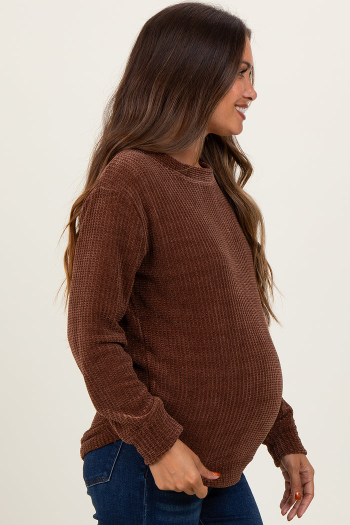 woman wearing a brown ribbed maternity sweater and showing her baby bump