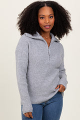 woman wearing a light gray zip-up sweater with a cozy knit texture and ribbed cuffs