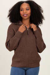woman wearing a brown zip-up sweater with a cozy texture and relaxed fit, posing with hands on her hips