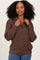 woman wearing a brown zip-up sweater with a cozy texture and relaxed fit, posing with hands on her hips