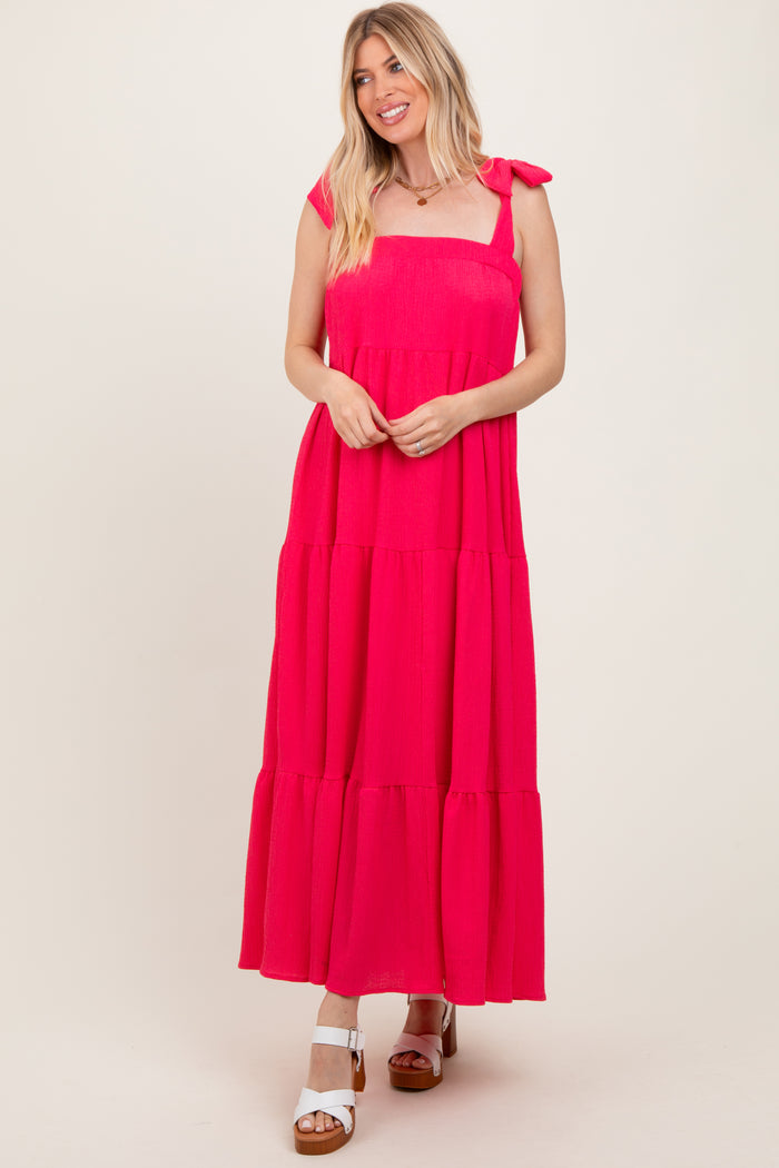 woman wearing a hot pink tiered maxi dress with tie straps and a relaxed fit