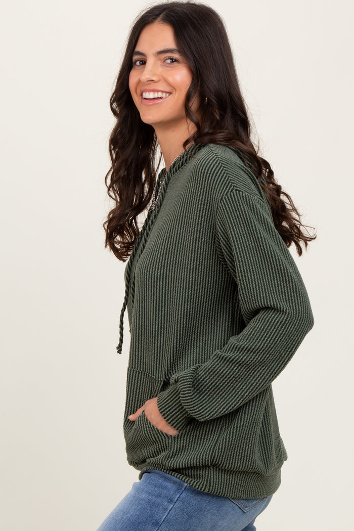 woman wearing a dark green textured hoodie with a front pocket and drawstring details