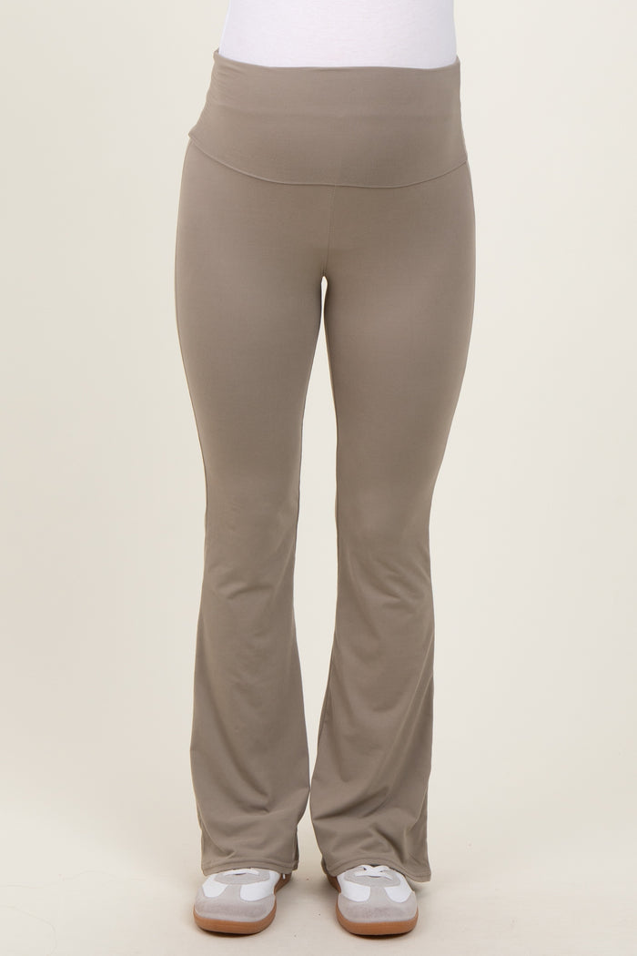 maternity wear in light taupe flared yoga pants with a wide waistband. model wearing the pants standing straight.