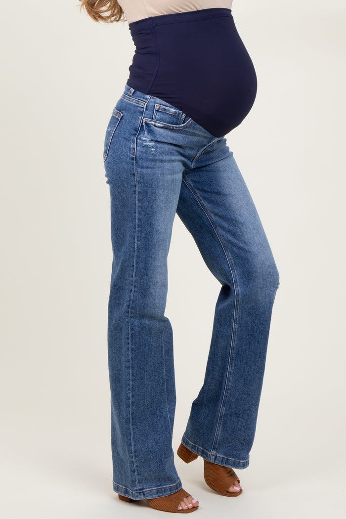 woman wearing a pair of blue maternity bootcut jeans with a navy belly panel and visible baby bump