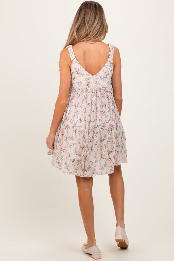 woman wearing a floral maternity dress with a scoop back and ruffled straps, showing a baby bump