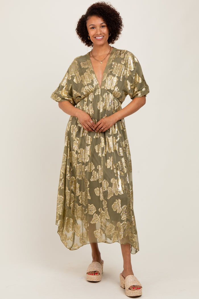 woman wearing a green floral print maxi dress with short sleeves and a deep v-neck, standing and smiling