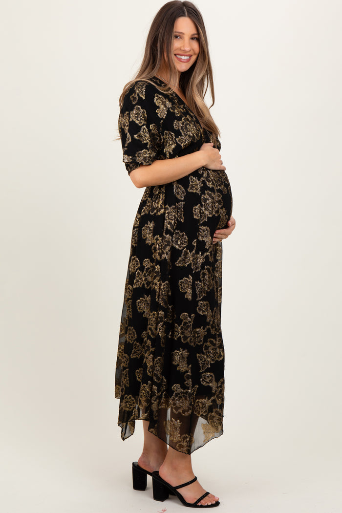 woman wearing a black floral print maternity maxi dress and showcasing her baby bump