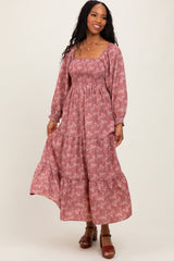 woman wearing a dusty rose floral maxi dress with long sleeves and a smocked bodice