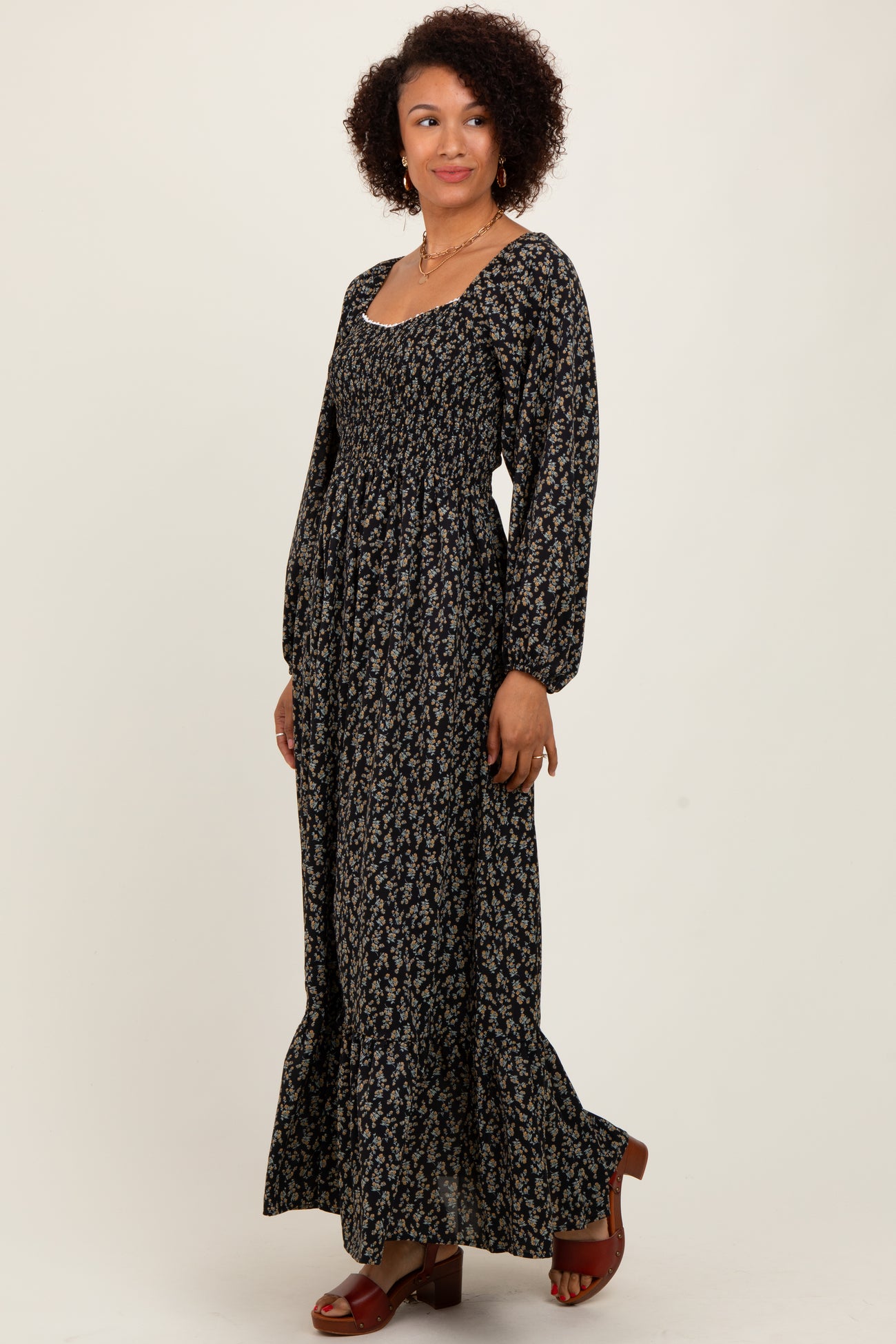 woman wearing a long black floral maxi dress with puff sleeves and a square neckline