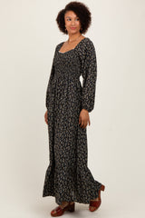 woman wearing a long black floral maxi dress with puff sleeves and a square neckline