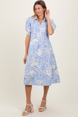 woman wearing a blue and white floral print midi dress with puff sleeves and a collared neckline