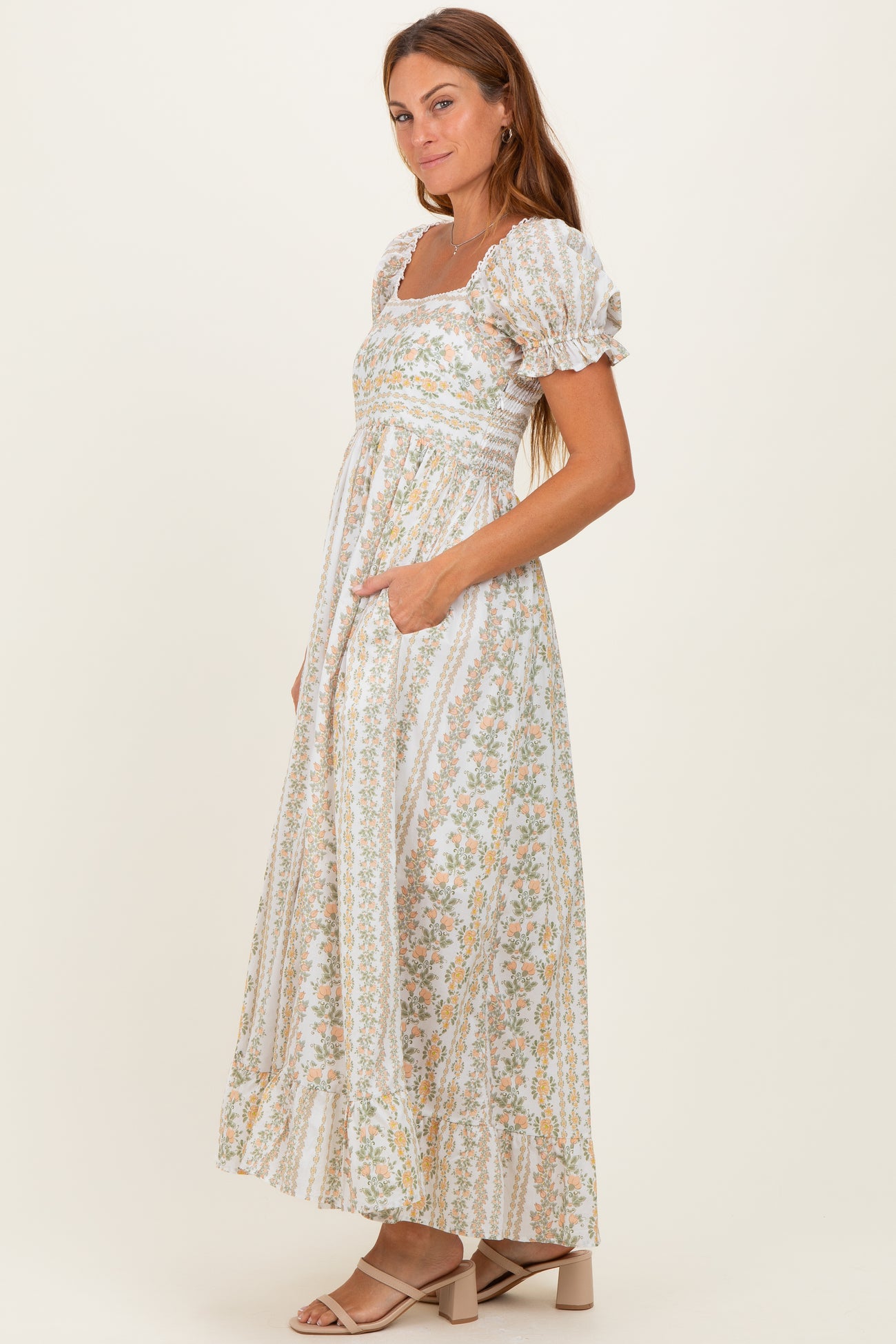 woman wearing a white floral maxi dress with puff sleeves and pockets
