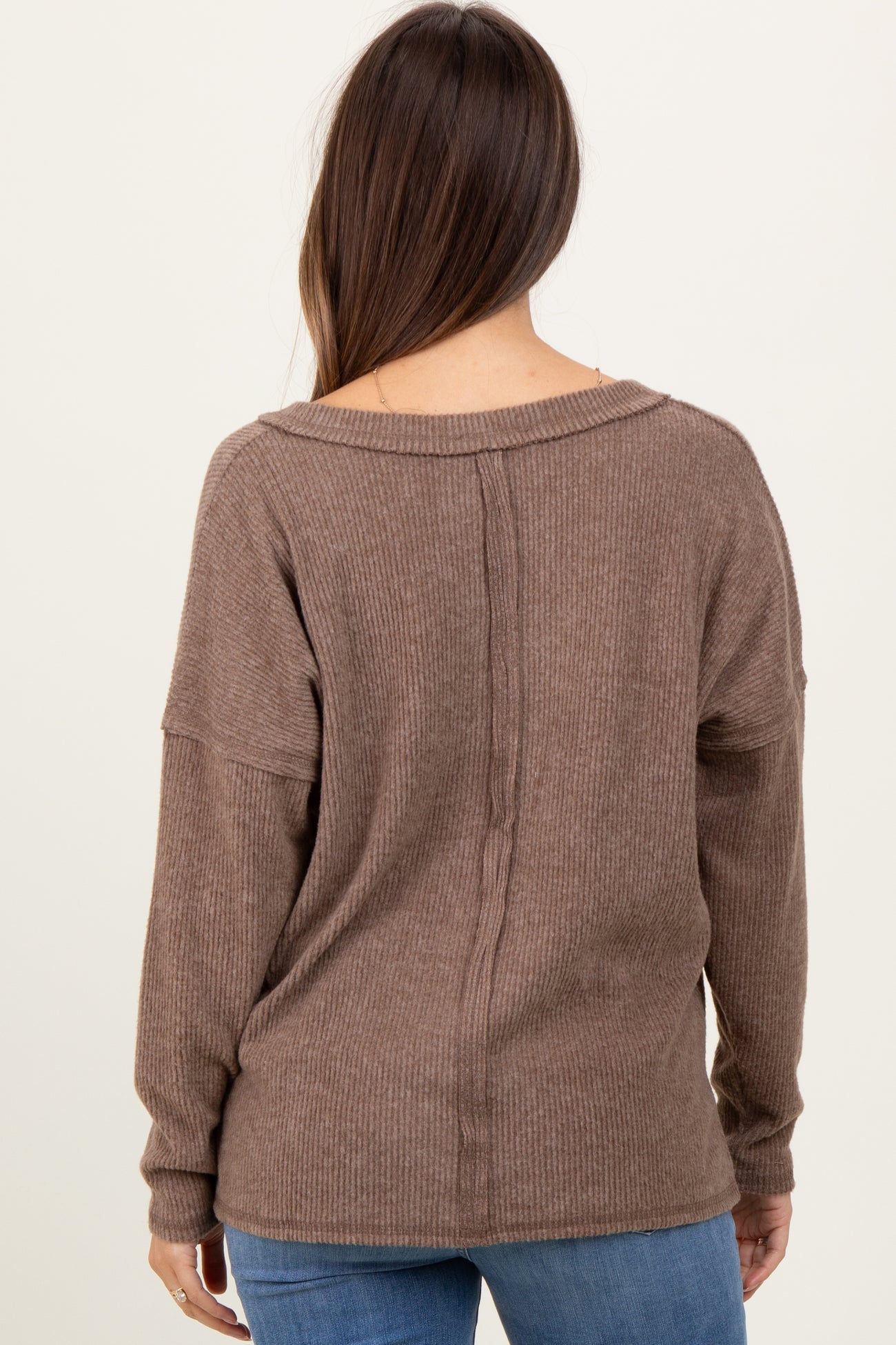 woman wearing a brown ribbed maternity sweater with a relaxed fit and dropped shoulder seams
