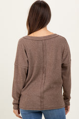woman wearing a brown ribbed maternity sweater with a relaxed fit and dropped shoulder seams