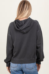 woman wearing a dark gray oversized hoodie with a hood, viewed from the back