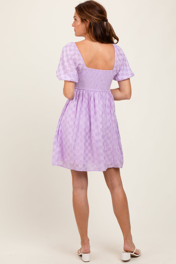 woman wearing a lilac checkered short sleeve dress with a square back and fitted bodice