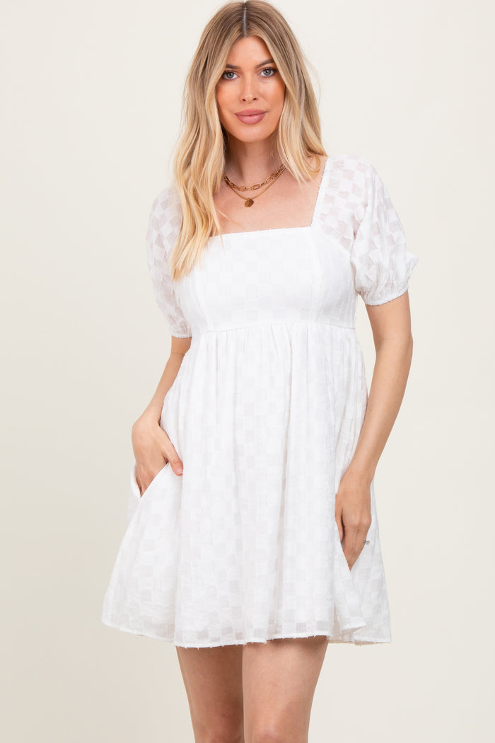 woman wearing a white short puff sleeve dress with a square neckline and pockets