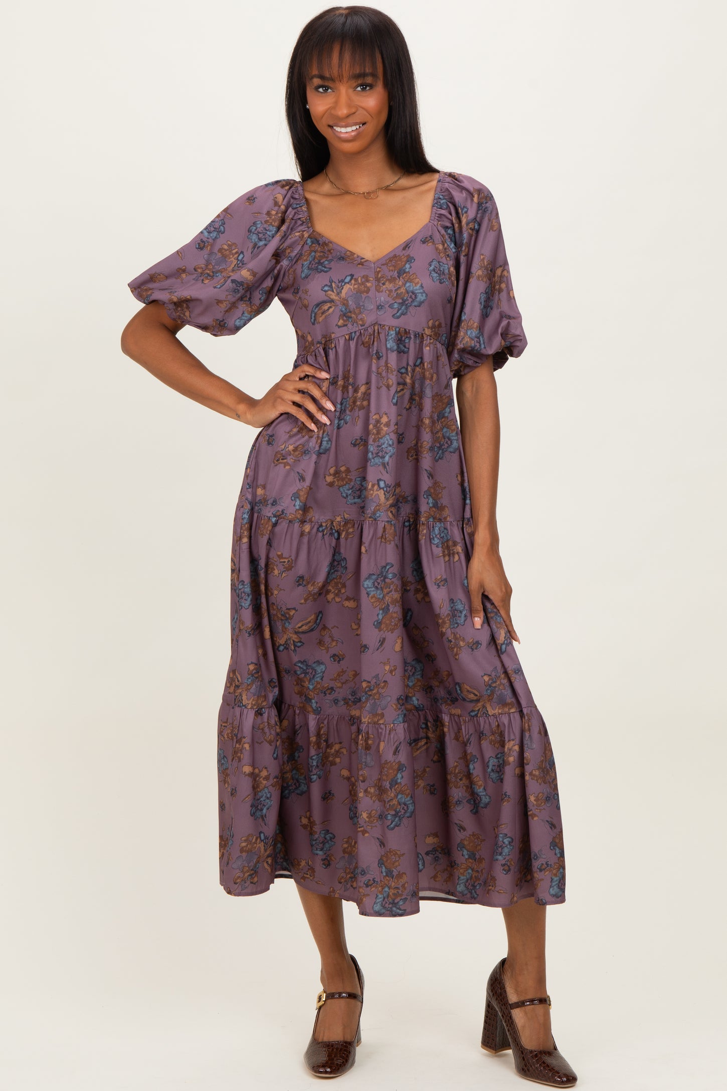 woman wearing a purple floral tiered maxi dress with puff sleeves and a v-neckline