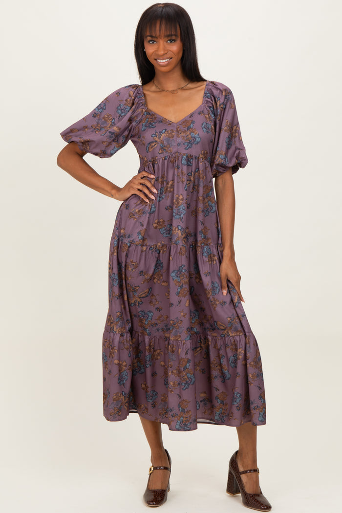 woman wearing a purple floral tiered maxi dress with puff sleeves and a v-neckline