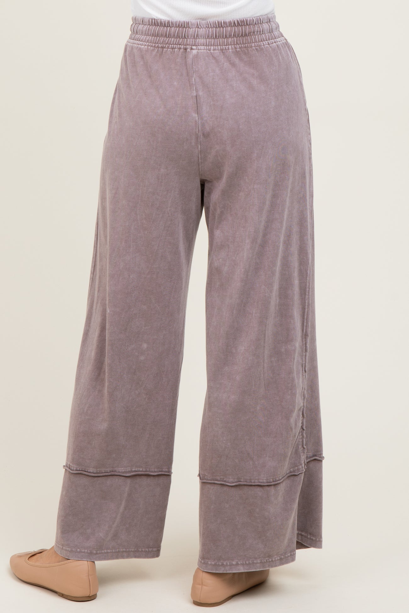 woman wearing soft lilac wide-leg pants with a relaxed fit and an elastic waistband, viewed from the back