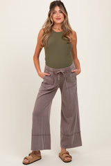 woman wearing olive green ribbed maternity tank top and grey wide-leg maternity pants with pockets and drawstring waist
