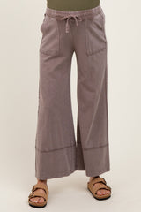 woman wearing light gray maternity wide-leg pants with pockets and drawstring waist, paired with brown sandals