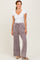 woman wearing a white short sleeve ribbed top and light purple wide-leg pants with pockets