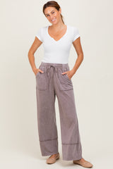 woman wearing a white short sleeve top and mauve wide-leg pants with pockets and an elastic waistband