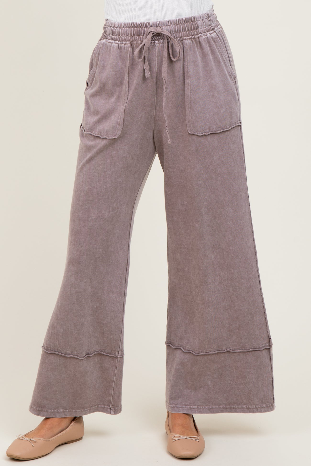 woman wearing mauve wide-leg lounge pants with front pockets and an elastic waistband