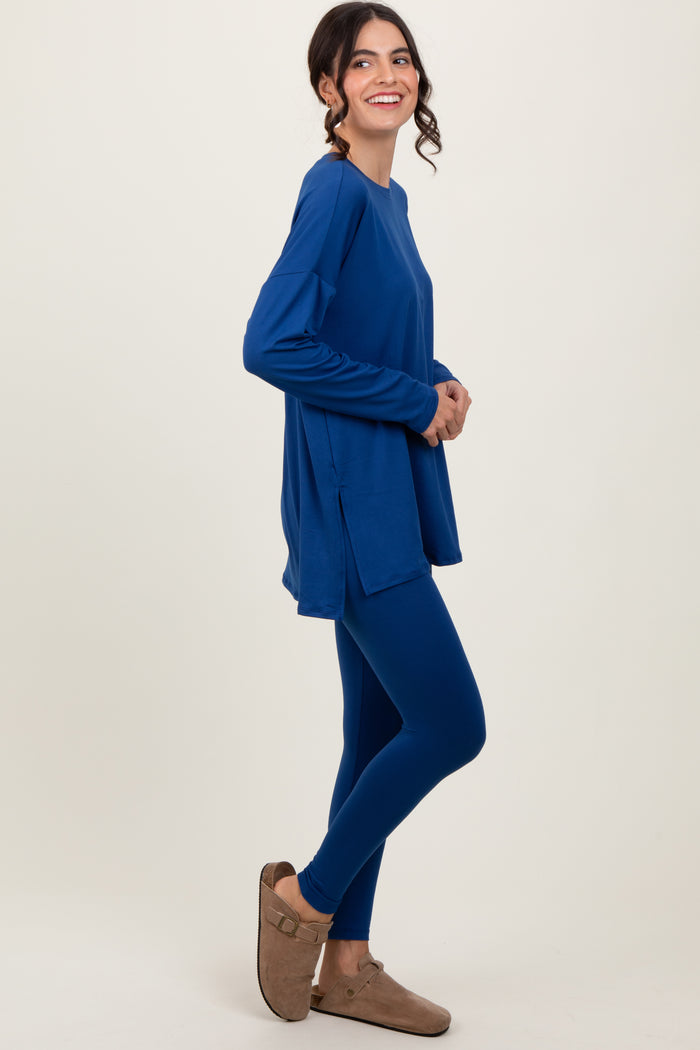 woman wearing a blue long sleeve tunic top with side slits and matching leggings, styled with brown slip-on shoes