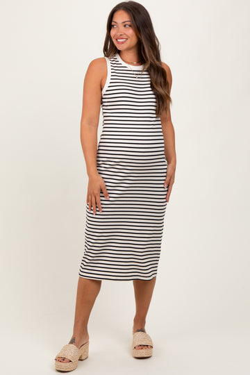 woman wearing a black and white striped maternity tank dress, standing and smiling, with a fitted silhouette