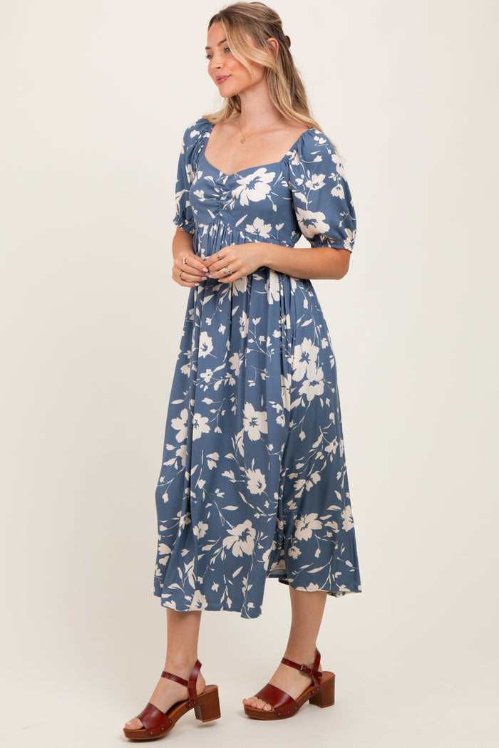 woman wearing a blue floral mid-length dress with puff sleeves and a square neckline