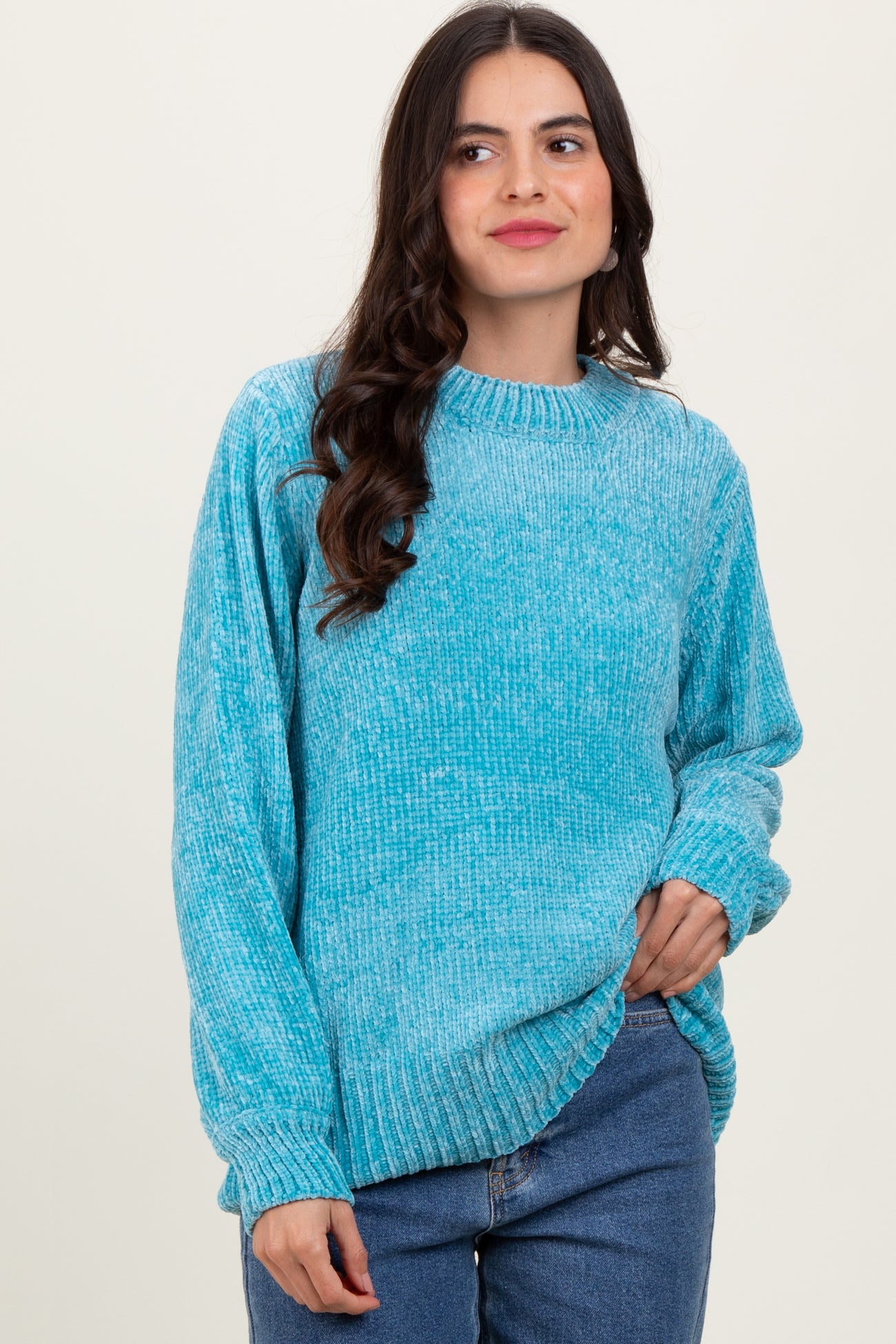 woman wearing a light blue oversized knit sweater with a round neckline and long sleeves